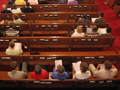 Parishioners sitting on church pews as seen from above.