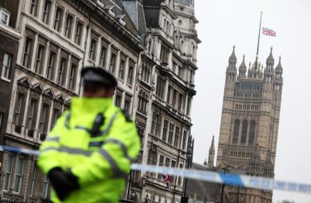 A police officer stands on duty as the union flag flies over Parliament at half-mast, London, England, March 23, 2017.