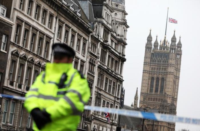 A police officer stands on duty as the union flag flies over Parliament at half-mast, London, England, March 23, 2017.