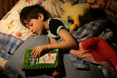 A six-year-old boy reads himself to sleep.