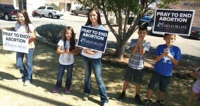 Young pro-life campaigners greet passersby with their anti-abortion message.