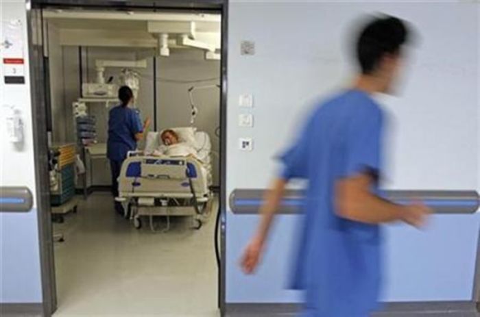 A nurse checks a patient in the intensive care unit at a hospital.