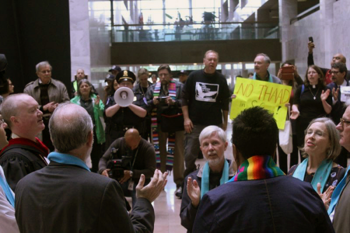 Seven faith leaders sign and pray as they demonstrate against the proposed budget of President Donald Trump at the Hart Senate Office Building in Washington, D.C. on April 24, 2017.