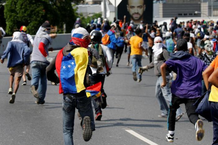 Demonstrators run away from tear gas during clashes with riot police while rallying against Venezuela's President Nicolas Maduro's government in Caracas, Venezuela April 24, 2017.