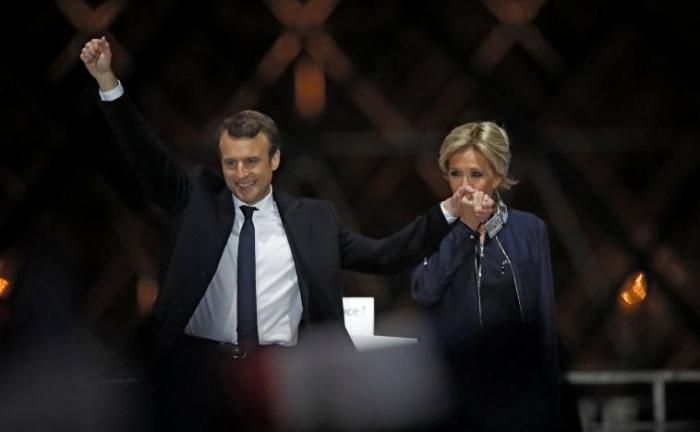 French President elect Emmanuel Macron and his wife Brigitte Trogneux celebrate on the stage at his victory rally near the Louvre in Paris, France May 7, 2017.