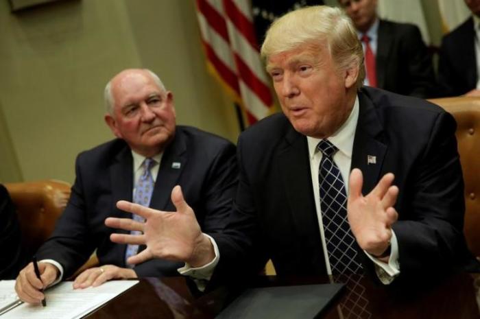 U.S. President Donald Trump talks to the media next to Secretary of Agriculture Sonny Perdue during a roundtable discussion with farmers at the White House in Washington, U.S. April 25, 2017.