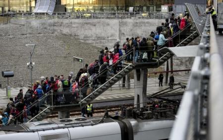 Police organize a line of refugees on a stairway leading up to trains arriving from Denmark at the Hyllie train station outside Malmo, Sweden, November 19, 2015.