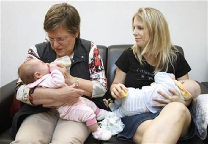 A woman (R) breastfeeds her baby while another one bottle-feeds another, during the Defi Allaitement (Breastfeeding Challenge) in Quebec City, on Sept. 24, 2011.