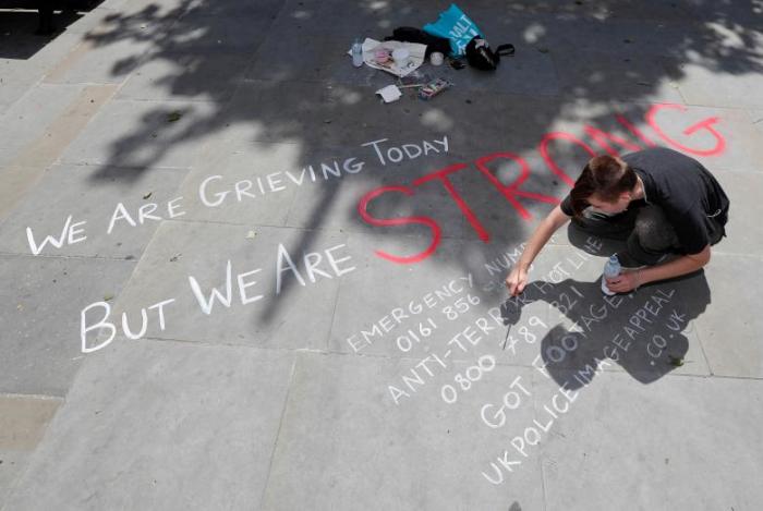 A man writes a message on the pavement in central Manchester, May 23, 2017.