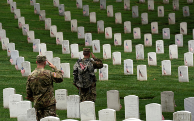 Soldiers from the 3rd U.S. Infantry Regiment (Old Guard) salute as Taps is heard nearby during 'Flags-in', where a flag is placed at each of the 284,000 headstones at Arlington National Cemetery, ahead of Memorial Day, in Arlington, Virginia, U.S., May 25, 2017.