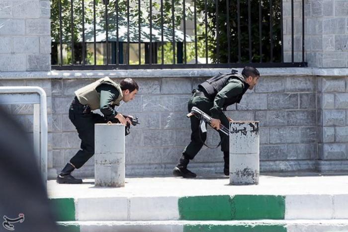 Members of Iranian forces take cover during an attack on the Iranian parliament in central Tehran, Iran, June 7, 2017.