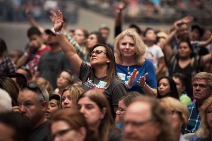 People worship at Harvest America at the University of Phoenix Stadium on June 11, 2017.