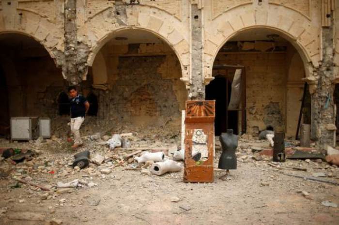 A boy walks past damaged pillars as Iraqis attend the first Palm Sunday procession in the burnt out main church of the Christian city of Qaraqosh since Iraqi forces retook it from Islamic States militants, Iraq April 9, 2017.