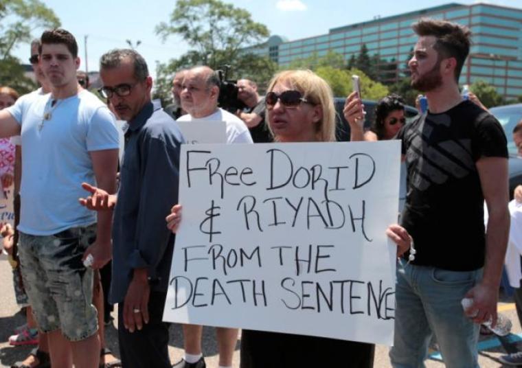 Chaldean-American Nadia Al-Raviah holds a sign protesting against the seizure of her husband and brother Sunday by Immigration and Customs Enforcement agents during a rally outside the Mother of God Chaldean church in Southfield, Michigan, U.S., June 12, 2017.