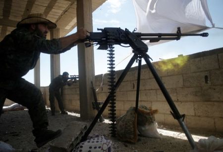 A Kurdish fighter from the People's Protection Units (YPG) fires heavy machine-gun at ISIS militants in Raqqa, Syria on June 21, 2017.