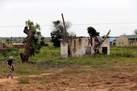 A woman walks toward a house damaged by Boko Haram militants, along the Konduga-Bama road in Bama, Borno, Nigeria, August 31, 2016.