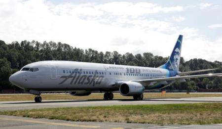 An Alaska Airlines plan rides on a runway. 