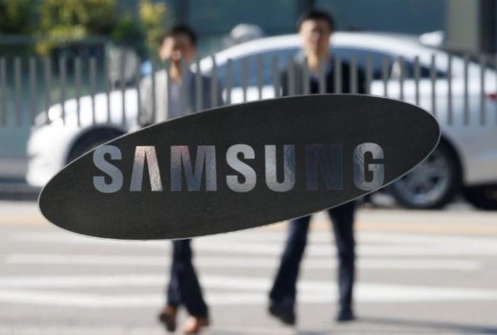 Employees walk past a building of Samsung Electronics in Seoul, South Korea, November 8, 2016.