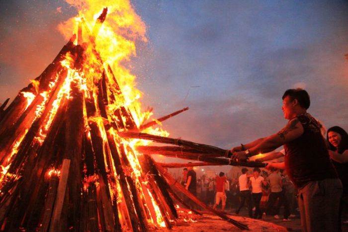 Ethnic Yi minorities and visitors surround fire as they celebrate the Torch Festival in Xichang, Sichuan province, China, in this undated photo.