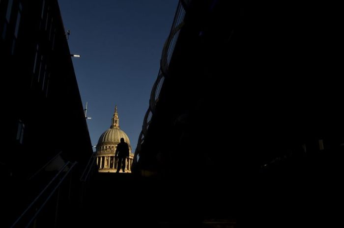 A City worker walks near St. Paul's Cathedral in the City of London, December 15, 2014.