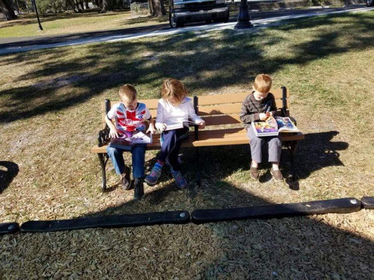 Kids reading the comic book version of the Bible by Kingstone.