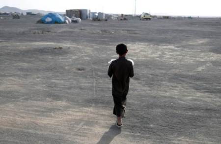 A boy, displaced from fighting in the Islamic State stronghold of Raqqa walks in desert as he carries bread near village of Karama, east of Raqqa, Syria July 1, 2017.