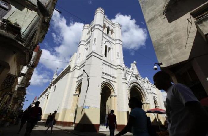 People walk near the Church of Our Virgin of Charity in Havana, Cuba, March 14, 2012.