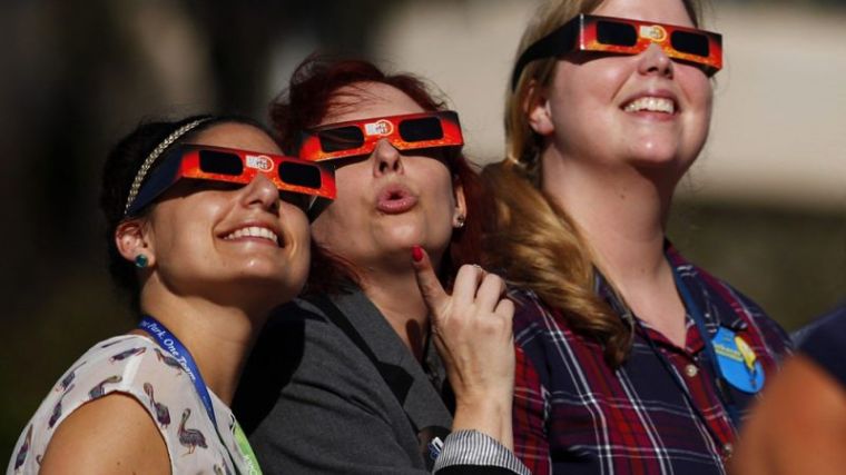 Women gaze up to view a partial solar eclipse outside the Reuben H. Fleet Science Center in San Diego, California, October 23, 2014.