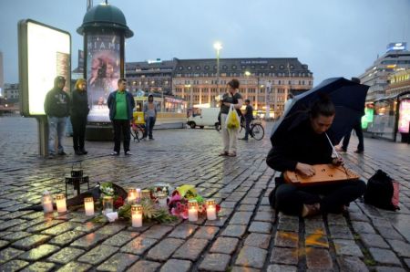 A woman plays a kantele, a traditional Finnish stringed instrument, in Turku's market square where several people were stabbed during a terrorist attack on Friday, August 18, 2017.