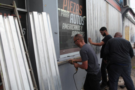 Men cover the windows of a auto parts store in preparation for Hurricane Irma, in San Juan, Puerto Rico September 5, 2017.