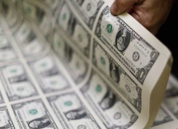 United States one dollar bills are curled and inspected during production at the Bureau of Engraving and Printing in Washington, D.C., November 14, 2014.