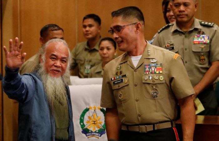 Marawi's vicar-general Father Teresito 'Chito' Soganub waves to the media and soldiers at a military camp, after soldiers rescued him from the Islamic State-linked rebels stronghold in Marawi, during a news conference in Quezon City, Metro Manila, Philippines September 18, 2017.