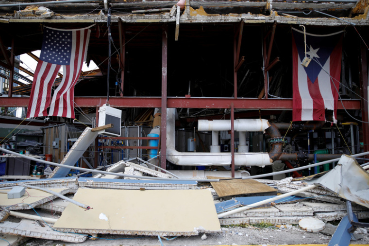 U.S. and Puerto Rico flags hang on a damaged church after the area was hit by Hurricane Maria in Carolina, Puerto Rico, September 26, 2017.