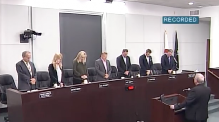 Members of the Brevard County Board of Commissioners pray as Pastor Tom Porter delivers the invocation at their budget hearing meeting, Sept. 26, 2017.