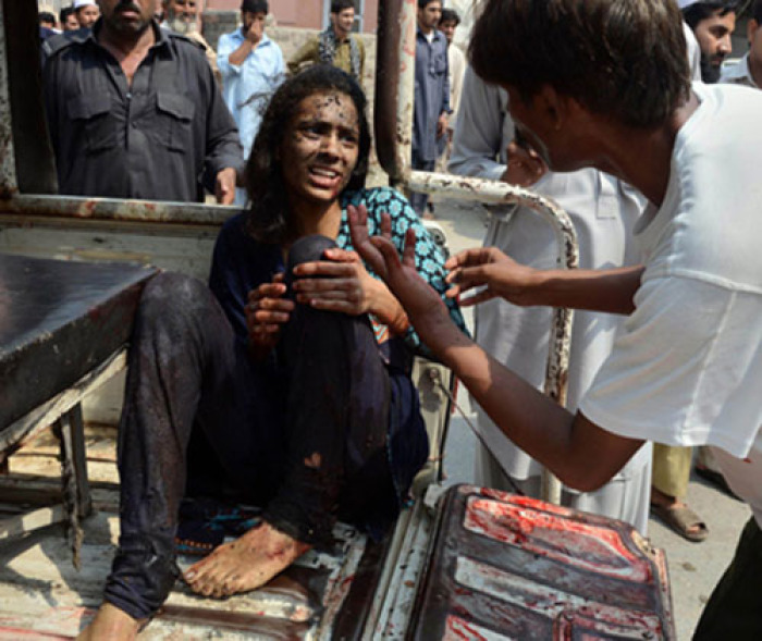 Kashmala Munawar holds her left leg after suffering an injury to her right leg in a bomb blast at All Saints Church in Peshawar, Pakistan on September 22, 2013.