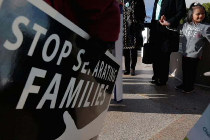 Demonstrators holding an 'Interfaith Prayer Vigil for Immigrant Justice' talk to ethnic Chinese Christians who fled Indonesia after wide scale rioting decades ago and overstayed their visas in the U.S., following their family meeting, including their five year-old daughter (R), with ICE, in Manchester, New Hampshire, U.S., October 13, 2017.