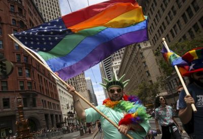 A man dressed as the Statue of Liberty carries a rainbow American flag while marching in a gay pride parade in San Francisco, California, in this undated photo.