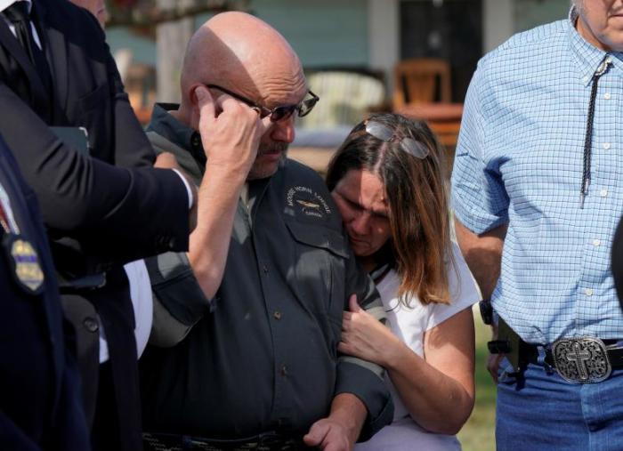 Pastor Frank Pomeroy, with his wife Sherri, listens at a news conference outside the site of the shooting at his church in Sutherland Springs, Texas, November 6, 2017.