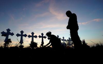 Judy Green places tiny American flags along a row of crosses as her husband Rod watches near the site of the shooting at the First Baptist Church of Sutherland Springs, Texas, November 7, 2017.