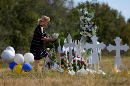 A woman places flowers at a memorial in memory of the victims killed in the shooting at the First Baptist Church of Sutherland Springs, Texas, November 7, 2017.