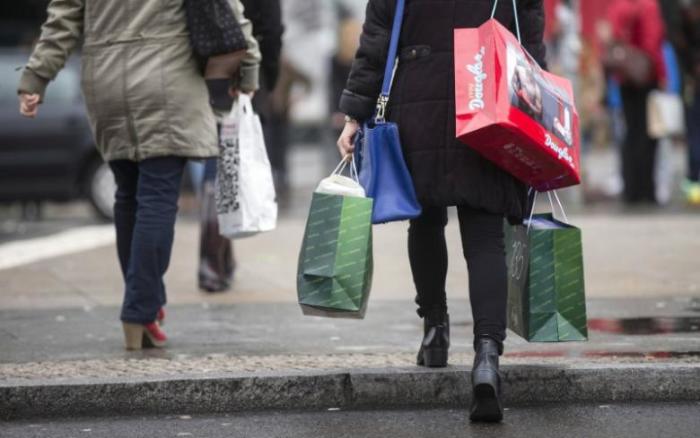 People carry bags outside a shopping mall on the last day of Christmas shopping in Berlin, December 23, 2014.