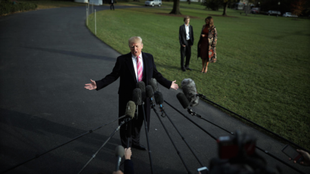 U.S. President Donald Trump talks with the reporters as First Lady Melania Trump and her son Barron wait for him while departing the White House for Palm Beach, in Washington D.C., U.S. November 21, 2017.