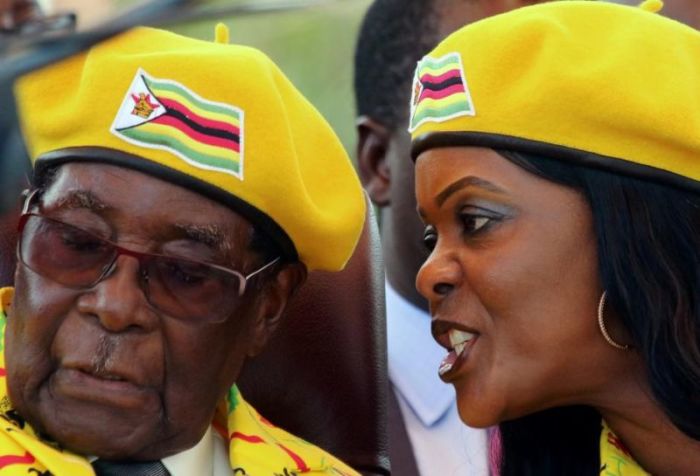 President Robert Mugabe listens to his wife Grace Mugabe at a rally of his ruling ZANU(PF) party in Harare, Zimbabwe, November 8, 2017.