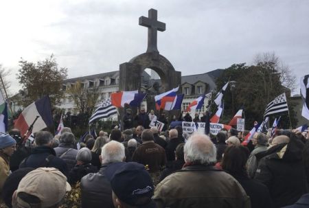 Demonstrators gather around a statue of Pope John Paul II in Ploermel, France on Nov. 26, 2017 in protest of a French court's ruling that a cross situated on a arch overlooking the statue must be removed.