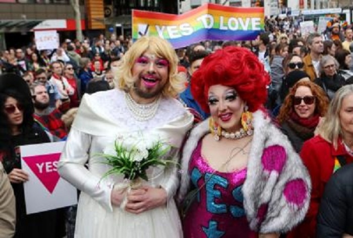 A man dressed in a wedding dress sands with other participants in a marriage equality march in Melbourne, Australia, on August 26, 2017.