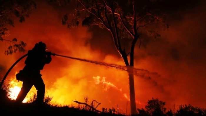 A firefighter is working on extinguishing the Lilac Fire, a fast moving wildfire in Bonsall, California, U.S., December 7, 2017.