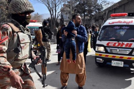 A man carries a boy as he shouts for an ambulance after gunmen attacked the Bethel Memorial Methodist Church in Quetta, Pakistan Dec. 17, 2017.