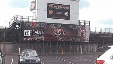 A church banner hangs outside the football stadium at New Palestine High School in New Palestine, Indiana.