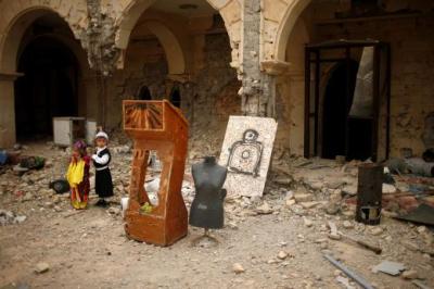 Boys visit the burnt out main church as Iraqis attend the first Palm Sunday procession in the Christian city of Qaraqosh on April 9, 2017.