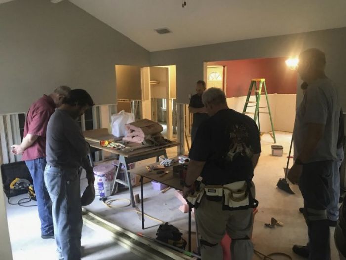 Volunteers with the relief agency LiveBeyond gather in a circle in prayer as they work on a house devastated by Hurricane Harvey in Southeast, Texas.